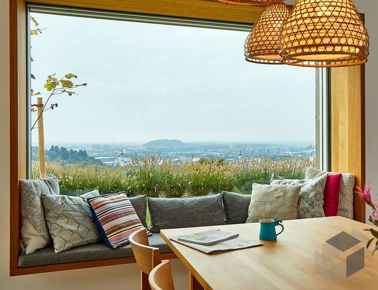 Une jolie banquette de fenêtre en aménagement intérieur avec de nombreux coussins pour plus de confort