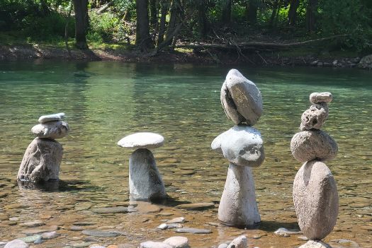Retrouver un équilibre harmonieux grâce à la libération transgénérationnelle comme ses pierres en équilibre les unes au dessus des autres dans une rivière.