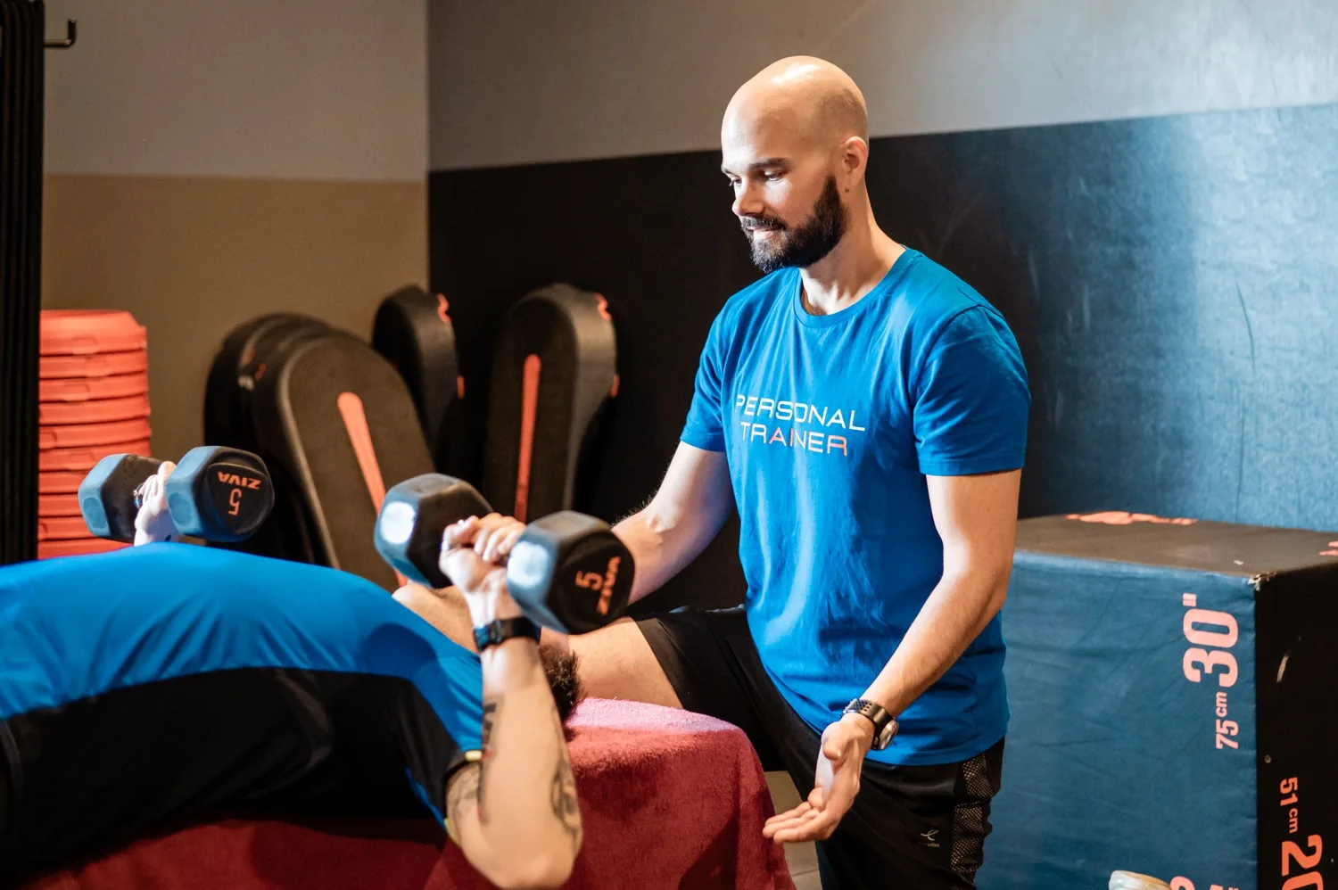 Thibault Marhic encadre un client en développé couché avec des haltères