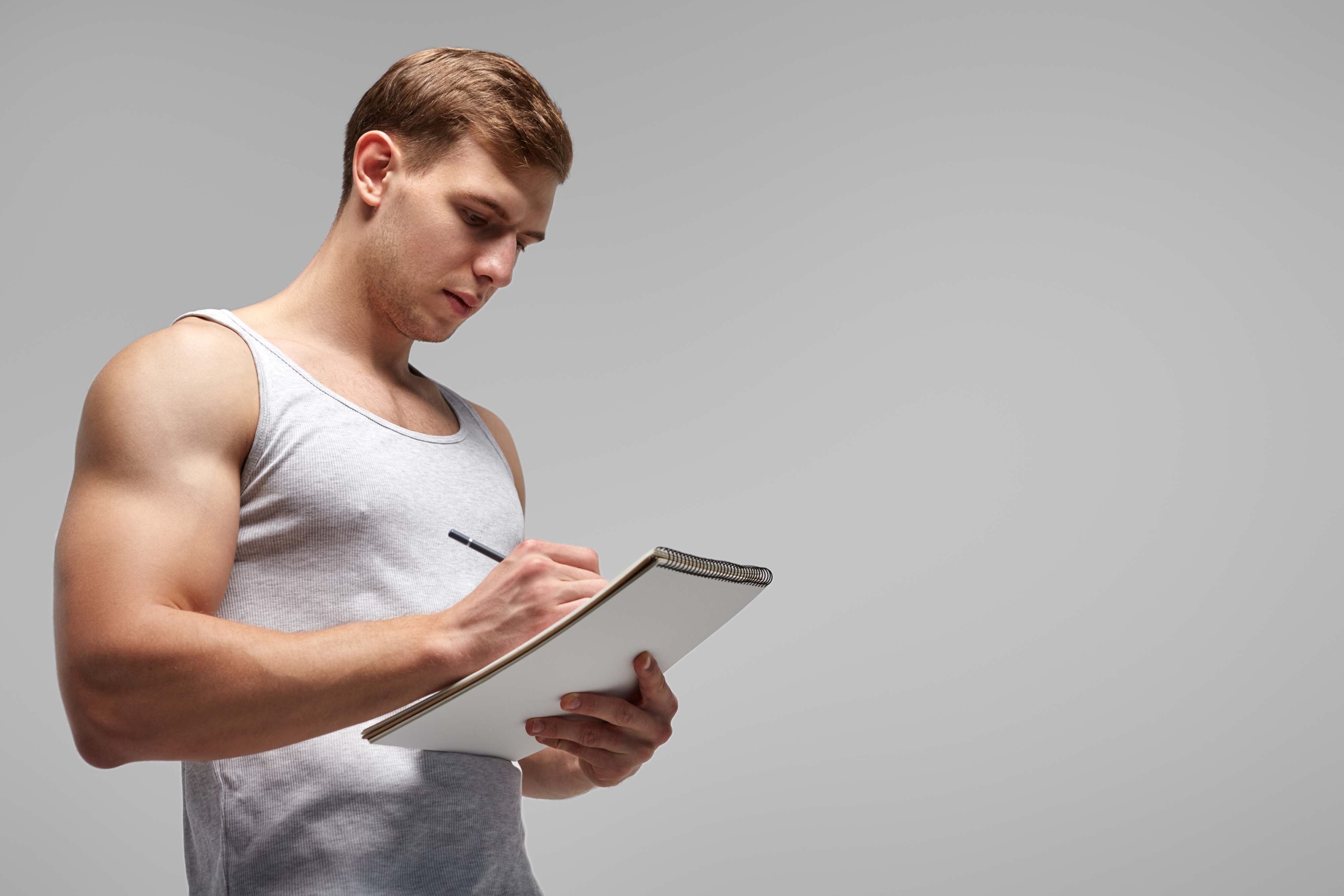 fit-trainer-writing-in-notepad-2023-11-27-05-07-11-utc